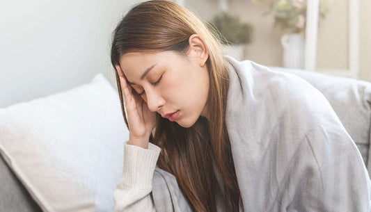 Woman feeling tired and stressed, illustrating causes of low energy and tips in article.